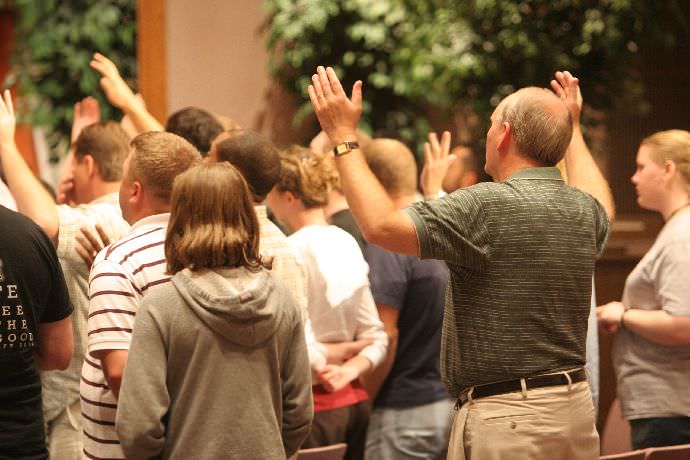 Student praising during worship service in Strickland Chapel.